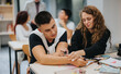 © qunica.com - A group of students are working together in a classroom, sharing ideas and helping each other with their studies. The learning environment is active and supportive, promoting teamwork and education.