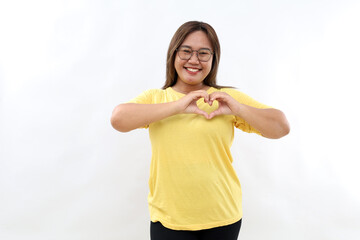 Lovely Asian woman with happy smile, shapes heart with both hands on left chest. Healthy heart concept. Isolated on white background