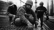 © altitudevisual - Three construction workers wearing hard hats and safety gear working with rebar at a construction site, focusing on manual labor and teamwork in an urban setting.