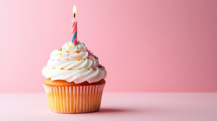 A single cupcake with a candle on a soft pink background, symbolizing a sweet and minimalist birthday celebration.