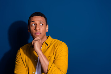 Poster - Portrait of nice young man look empty space wear yellow shirt isolated on dark blue color background