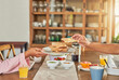 © TamJam/peopleimages.com - Hands, breakfast and toast with couple at dining table for health, morning and cooking. Helping, nutrition and brunch food with closeup of people eating at home for hunger, diet and wellness