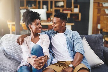 Poster - House, talk and black couple on sofa, love and relax with happiness, bonding together and calm. Apartment, people or man with woman, relationship and marriage with joy, cheerful or speaking in lounge