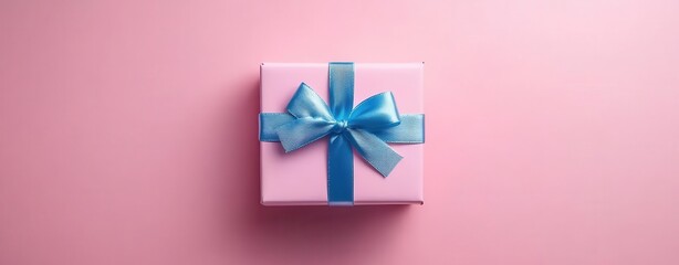 Decorative pink gift box with blue ribbon on a soft pink background.