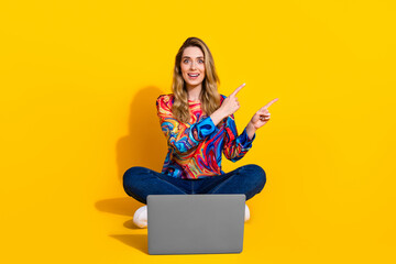 Wall Mural - Full size photo of pretty young girl netbook point empty space wear trendy colorful outfit isolated on yellow color background