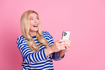 Poster - Photo of adorable cheerful woman wear trendy striped clothes hold modern device isolated on pink color background