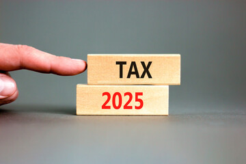 Planning tax 2025 new year symbol. Concept words Tax 2025 on beautiful wooden blocks. Beautiful grey background. Businessman hand. Business tax 2025 new year concept. Copy space.