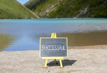 Successful symbol. Concept word Successful on beautiful chalk blackboard. Mountain lake. Beautiful mountain lake background. Business successful concept. Copy space.