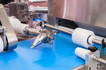 Poster - A machine is making a pastry with a green frosting. The machine is in a factory. The pastry is being made in a large industrial setting