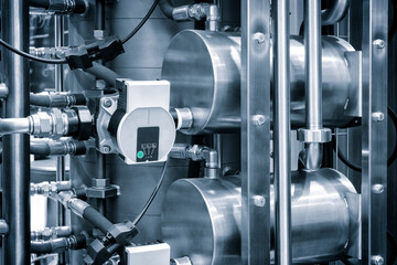 Poster - A large industrial machine with many pipes and valves. The machine is made of metal and has a blue and white color scheme