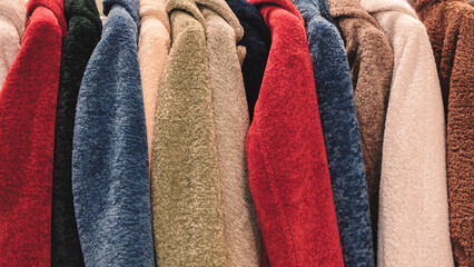 Poster - A row of colorful fuzzy jackets are displayed. The jackets are of different colors and styles, and they are arranged in a neat row. Concept of warmth and comfort
