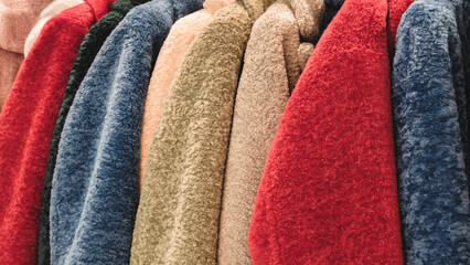 Poster - A row of colorful fuzzy jackets are displayed. The jackets are of different colors and styles, and they are arranged in a neat row. Concept of warmth and comfort