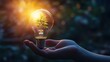 © logyartstudios - A hand holds a lightbulb with a green plant growing inside, symbolizing a sustainable future.