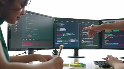 Slow motion back end software developer engineer for computer programming working together on debugging writing computing code, solving complex algorithms display on monitor in office. Burgeoning