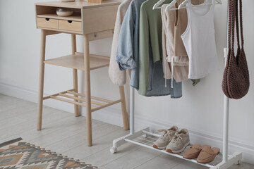 Canvas Print - Rack with clothes, shoes and standing desk near white wall