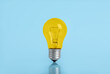 © New Africa - One yellow bulb on light blue background
