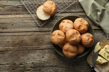 Canvas Print - Homemade tasty buns, butter and knife on wooden table, flat lay. Space for text