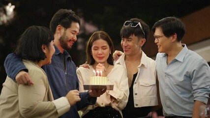 Wall Mural - Group of Happy Asian millennial people friends enjoy and fun celebration birthday party at dinner party the garden at restaurant. Beautiful woman excited with birthday cake and blowing candle.