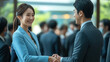 © 沈军 贡 - An Asian business man and woman shake hands at a business event