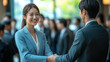 © 沈军 贡 - An Asian business man and woman shake hands at a business event