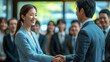 © 沈军 贡 - An Asian business man and woman shake hands at a business event
