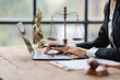 © Kritdanai - Lawyer Working on Laptop with Legal Symbols in Background