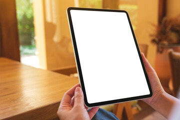 Wall Mural - Mockup image of a woman holding digital tablet with blank desktop screen at home