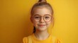 © liliyabatyrova - A young girl wearing glasses and a yellow shirt is smiling at the camera
