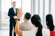 © sorapop - In a conference, hands are raised for questions, symbolizing audience participation and interactive learning. A diverse group collaborates at a workshop or seminar, promoting teamwork and discussion.