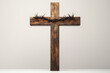 © reddish - Wooden cross with a crown of thorns on a plain background