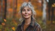 © Nataliia_Trushchenko - Woman with gray hair and a plaid jacket is smiling. forest with autumn leaves. middle aged woman in all flannel with small brown stains on her clothes, standing in the middle of a maple forest