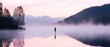 © TPS Studio - A tranquil scene of a lone figure standing in a misty lake at dawn, surrounded by mountains and soft pastel colors.