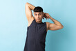 © luismolinero - Young Colombian man isolated on blue background stretching arm