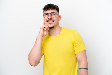 Young caucasian handsome man isolated on white background thinking an idea while looking up