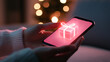 © enterdigital - A person holds a phone displaying a glowing gift box graphic, symbolizing digital gifting during the festive season.