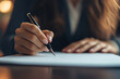© Alina - Businesswoman signing a document with a pen