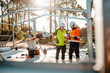 © Austockphoto - Focus on ute behind two construction site managers looking at digital blueprints