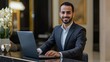 © Lion - Professional Middle Eastern receptionist in formalwear at the reception desk of a high end hotel, clean and minimalistic image.