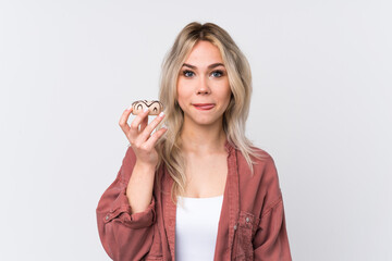 Wall Mural - Teenager blonde girl over isolated white background holding a donut