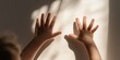 © gunzexx png and bg - This image captures the silhouette of a child's hands on a sunlit wall, conveying innocence, curiosity, and the beauty of light and shadow interplay.