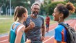 © COK House - Four people in sportswear on a track: man with gray hair, woman in white/blue, woman in blue/orange shorts, and a jogger in the background. Shows camaraderie and relaxation during