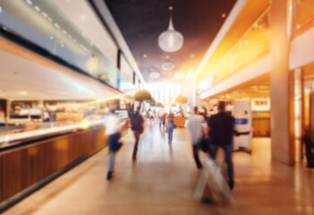 Poster - Blurred view of people walking through a modern interior space with wood accents and a large window.