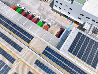 Solar-powered warehouse facility with freight trucks at loading docks. Eco-friendly logistics and efficient cargo transportation. Solar panels and sustainable energy concept in distribution center.