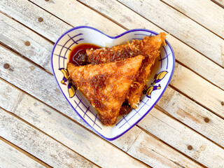 Lupis Indonesia traditional sweet cake, glutinous rice with triangle shaped with toppings grated coconut and brown sugar sauce.