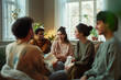 © Syuzann q - Group of young friends casually talking in a cozy living room with natural light, surrounded by plants and comfortable seating.