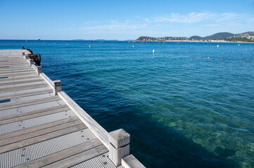  Morning view on crystal clear blue water of Plage du Debarquement white sandy beach near Cavalaire-sur-Mer and La Croix-Valmer, summer vacation on French Riviera, Var, France