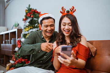 A joyful couple enjoys the holiday spirit, dressed in festive attire and surrounded by decorations