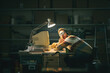 © StockPhotoPro - Nerd guy falling asleep at his desk in the garage