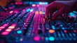 © Joachim - An audio technician's hand working on a mixing board, set against a vibrant backdrop of colored lights, symbolizing creativity in music production artistry.