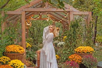 American blonde Woman in long white lace Boho dress with sleeves and fringe, fashionable outfit concept